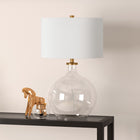 Hudson&Canal - Lampe de table Laelia 63 cm de haut avec abat-jour en tissu - Verre transparent/laiton/blanc-Une finition artisanale en verre transparent et en laiton est appliquée sur la base ronde en verre