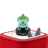 tonies - Pokemon Bulbizarre Bulbasaur (Anglais)-Tracklist: 01. Meet Bulbasaur 02. Introduction to the World and Characters 03. Story 1.: Bulbasaur’s Clever Escape 04. Trainer Academy: Pokémon Moves 05. Pokémon Power Moves 06. Story 2.: Bulbasaur and the Campfire Mystery 07. Trainer Academy: Where to Find Pokémon 08. Story 3.: Bulbasaur to the Rescue 09. Concluding Segment Running time: 1. h 1.9. min +