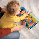 Manhattan Toy - Livre sensoriel Bugging Through-Chaque page comporte une découpe ronde pour y faire passer un insecte attaché.