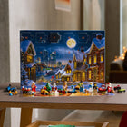 LEGO - City Le calendrier de l’Avent 2025-Tapis de jeu festif - Les enfants déplient la boîte pour révéler une scène de fête de Noël, où ils peuvent jouer des histoires et des aventures festives avec les miniconstructions et les personnages inclus