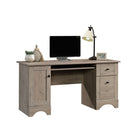 Sauder 59"W La Collection Sauder Select Bureau - Finition Laurel Oak-  L'espace de rangement derrière la porte peut contenir une tour CPU verticale et dispose d'une étagère réglable